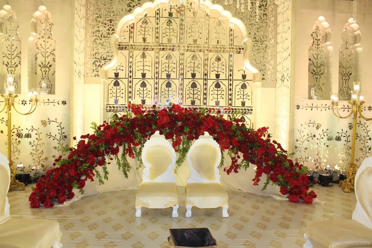 A mandap built by Arika Event, red roses over ivory seating
