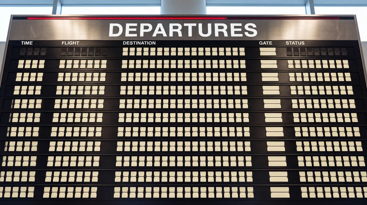 Airport departures hall at dusk with a soft-focus board